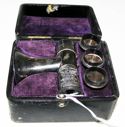 Mayer & Metzler Brunton Auriscope in black case with purple velvet inside lining.