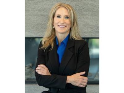 Dr. Kathleen Flarity smiling, with long blond hair, wearing a blue blouse and black blazer.