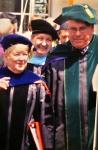 Maureen, Dean Richard Krugman, MD, and another woman walk together at a School of Medicine graduation ceremony. All are in academic regalia.
