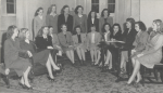 Black-and-white group portrait of the women in the Entre-Nous club at Mississippi State College for Women. Most of the women are seated in suit skirts.