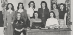 Black-and-white group photo of the editors for the 1948 Mey Lady Yearbook at MSCW. The women are seated and standing around a wooden desk with a typewriter on it.