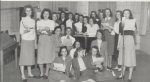 Black-and-white group portrait of the women in the Theater Guild at Mississippi State College for Women. Most of the women are standing in white blouses and light-colored calf-length skirts.