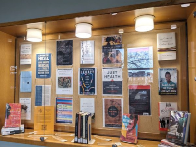 Books on race and medicine on display in glass case.