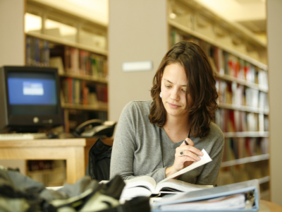 Student studying with books in library