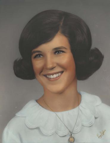 Formal portrait of Maureen Garrity with a dark bouffant styled hair and wearing a white top with a scalloped collar and a gold necklace with a small pendant.