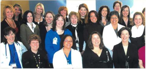 Group photo of University of Colorado Hospital’s Department of Professional Resources staff, some in white lab coats and name badges.