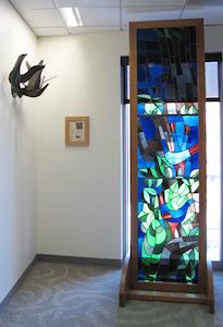 Wall hanging of Doves and Stained glass depicting angular and abstract birds walking 